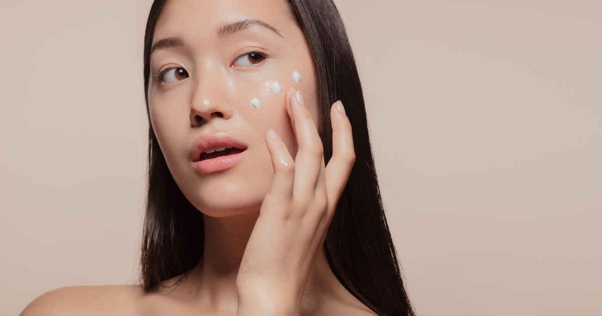 a woman applying moisturizer to dry skin on her face